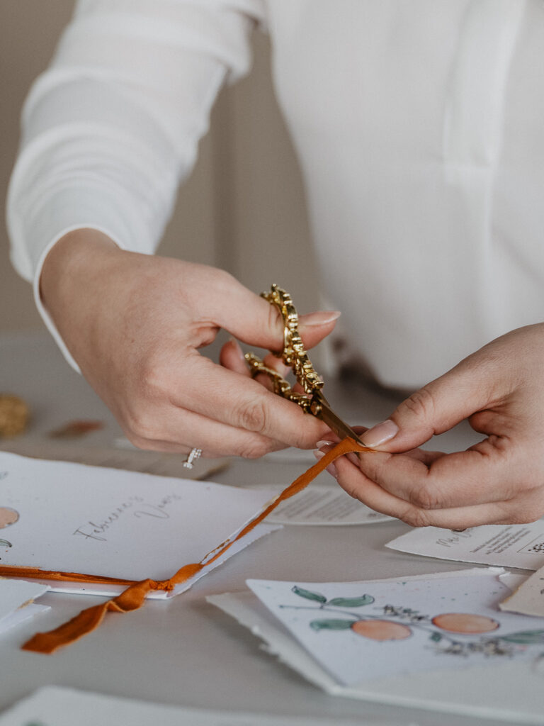 zuschneiden eines Seidenbandes als Veredelung von Hochzeitspapeterie