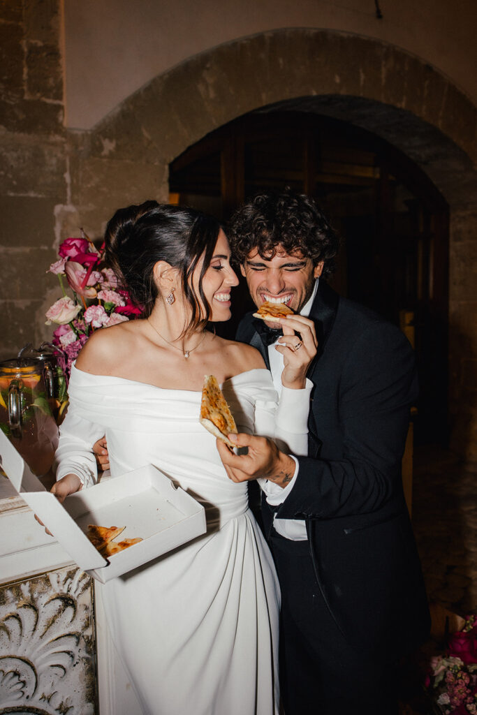 Brautpaar isst Pizza als Mitternachtssnack auf einer Hochzeit auf Mallorca