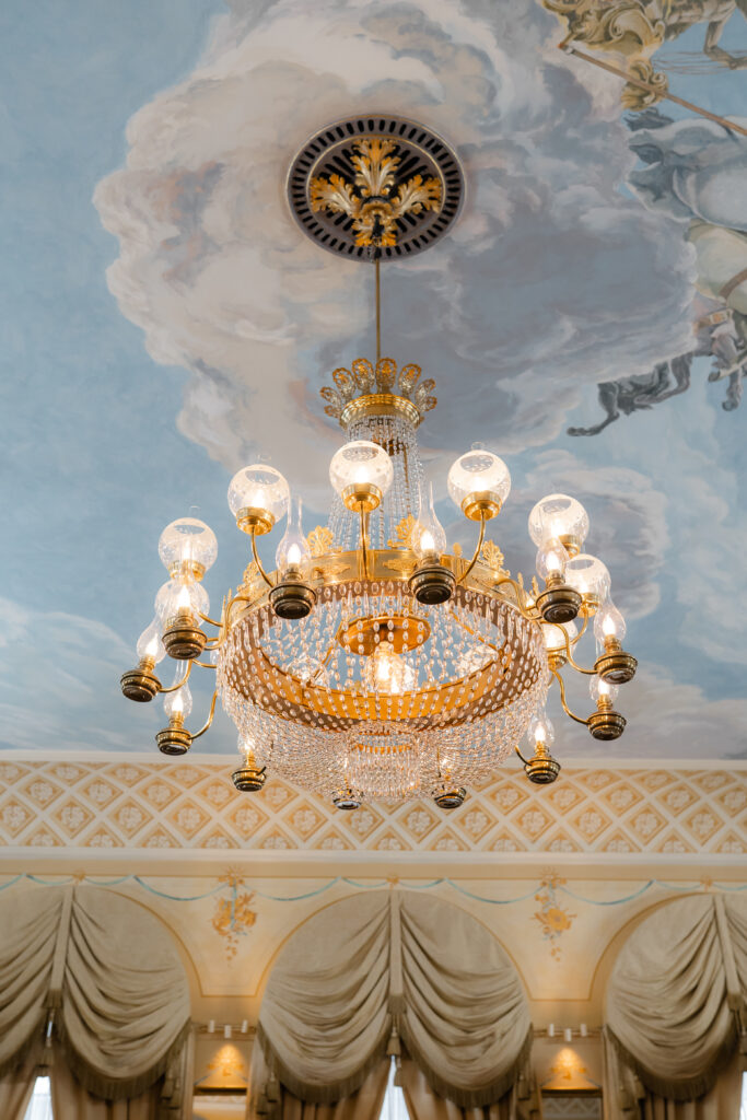 Luxuriöser Kronenleuchter mit kunstvoll bemalter Decke