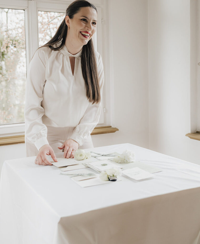 Francine, Inhaberin von Fancy Design beim Flat Lay legen von luxuriöser Hochzeitspapeterie